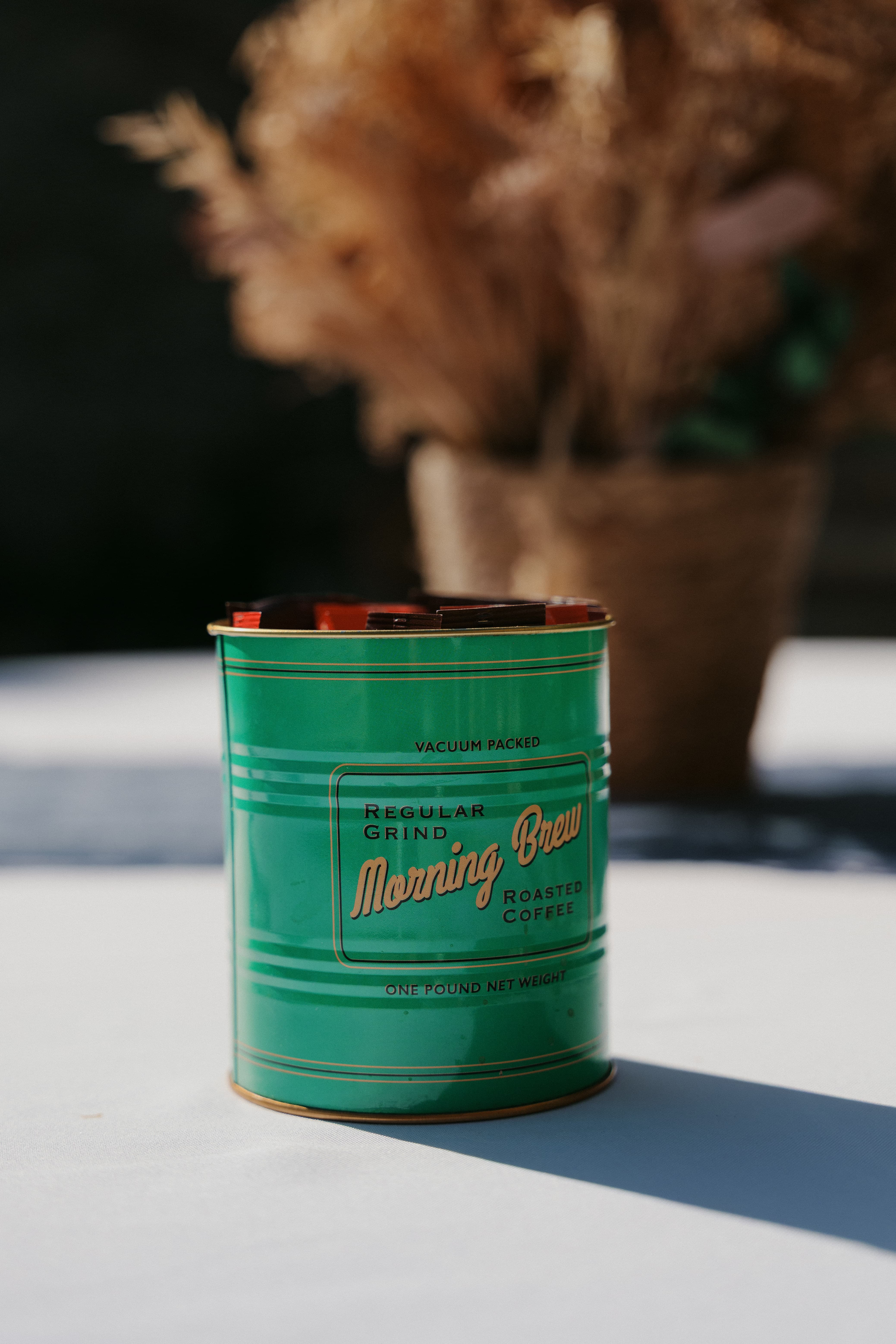 Boîte vintage verte sur une table ensoleillée du Café Noisette