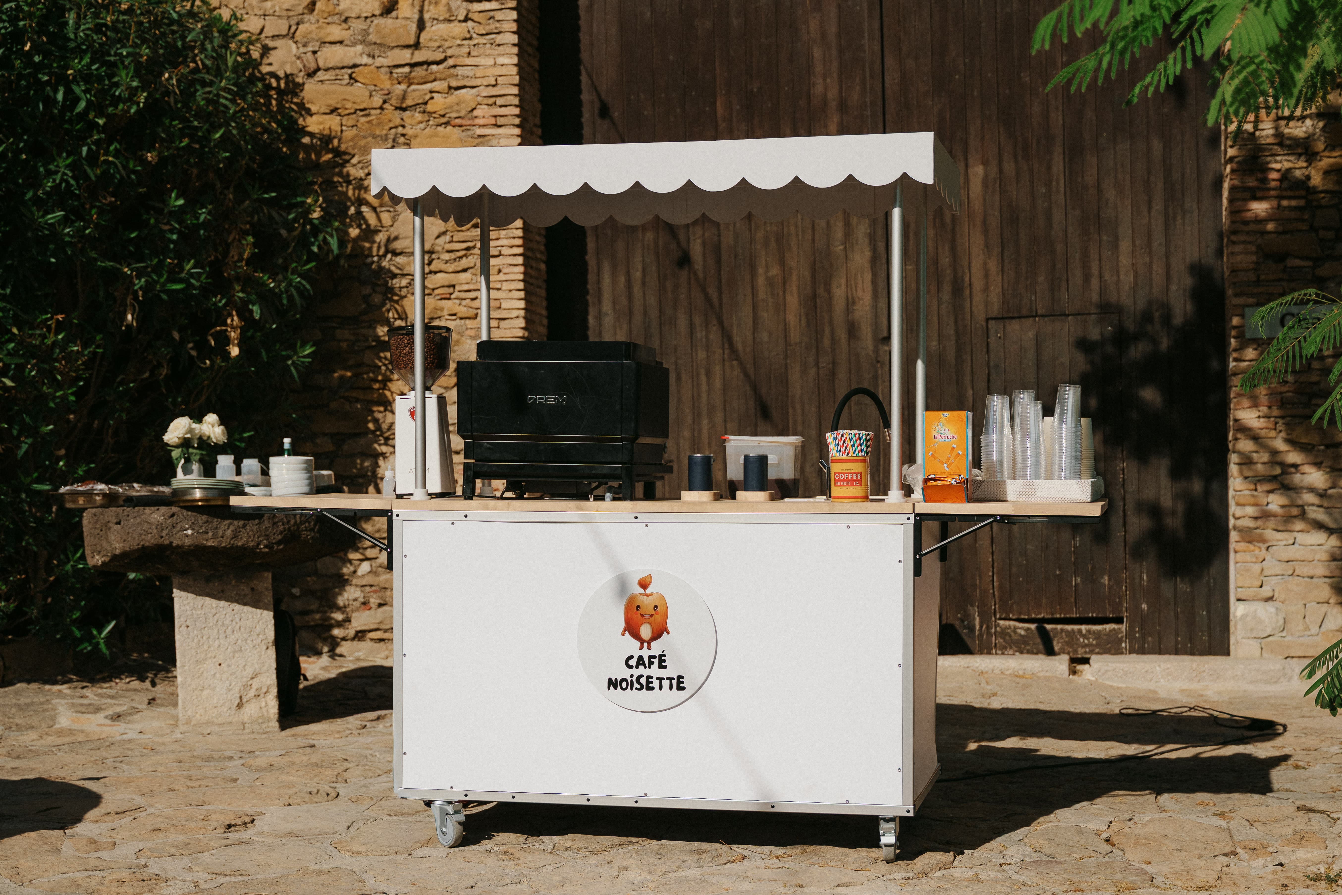 Le coffee cart Café Noisette devant une bâtisse en pierre